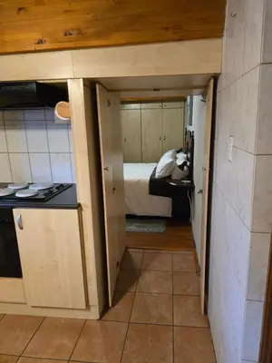 a small room with a bed and a kitchen at Urban Retreat in Cape Town
