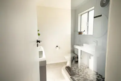 a white bathroom with a sink and a toilet at Ocean Whisper Unit 79 in Hermanus