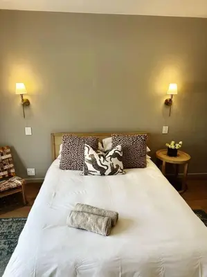 a bedroom with a large white bed with pillows at Stellenbosch Winelands Apartment in Stellenbosch
