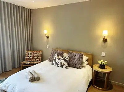 a bedroom with a white bed with pillows on it at Stellenbosch Winelands Apartment in Stellenbosch