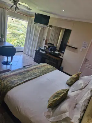 a bedroom with a large bed with two pillows on it at Lumley's Place Guesthouse in Pniel