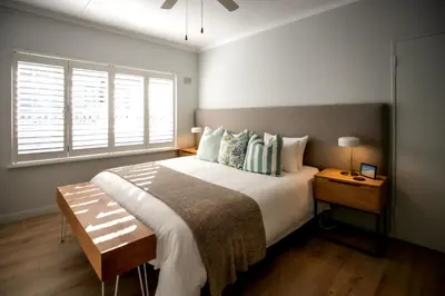 a bedroom with a large bed and a window at Happy Hideaway in Hermanus
