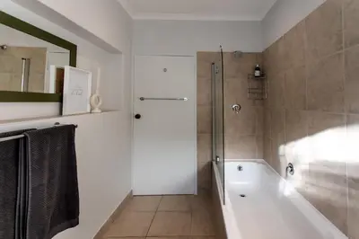 a bathroom with a bath tub and a shower at Happy Hideaway in Hermanus