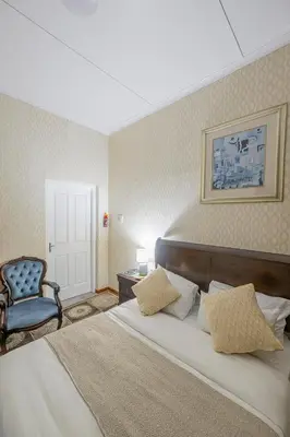 a bedroom with a large bed and a blue chair at Prime Executive Accommodation in Cape Town