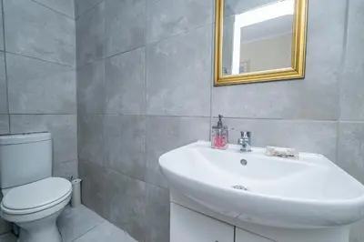 a bathroom with a sink and a toilet and a mirror at Prime Executive Accommodation in Cape Town