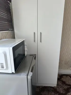 a microwave oven sitting on top of a refrigerator at Prime Executive Accommodation in Cape Town