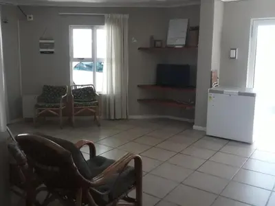 a living room with two chairs and a refrigerator at Tolbos Backpackers in Worcester