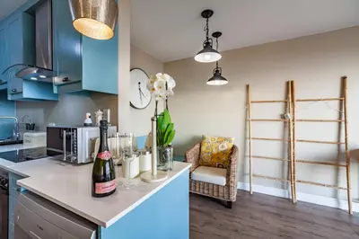a kitchen with blue cabinets and a counter with wine bottles at Beachfront Luxury Living- A106 Seaspray, Blouberg in Bloubergstrand