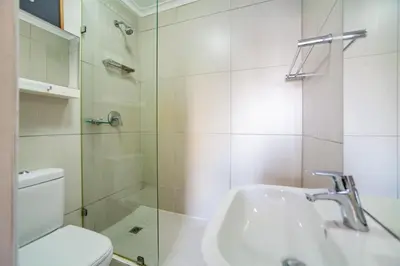 a bathroom with a shower and a sink and a toilet at Beachfront Luxury Living- A106 Seaspray, Blouberg in Bloubergstrand