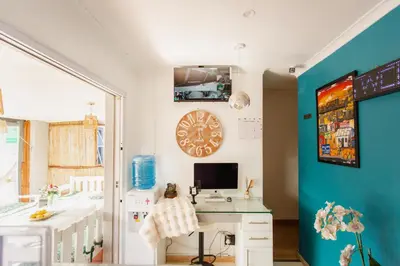 a room with a desk and a clock on the wall at Caline VIP Luxury Jacuzzi &, Swimming Pool MEWS in Cape Town