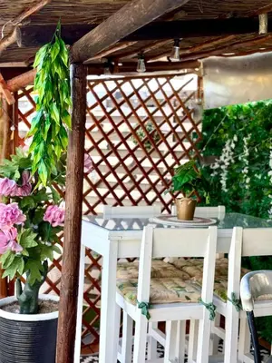 a table and chairs under a pergola with flowers at Caline VIP Luxury Jacuzzi &, Swimming Pool MEWS in Cape Town