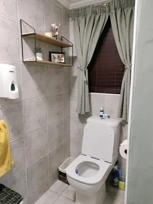 a bathroom with a white toilet and a window at Champers in Cape Town