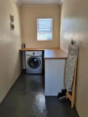 a laundry room with a washing machine and a counter at Fortune Cottage in Cape Town