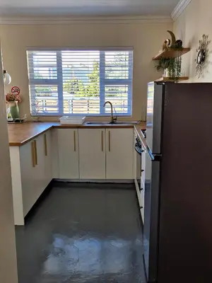 a kitchen with a sink and a refrigerator at Fortune Cottage in Cape Town