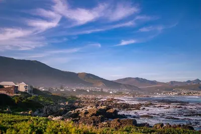 a view of the ocean with mountains in the background at Seascape, Vermont Retreat in Hermanus