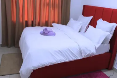 a bed with a stuffed animal on top of it at Brooklyn Queens and Kings Guesthouse in Cape Town