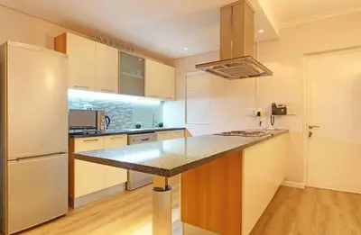 a kitchen with a counter top and a refrigerator at Private Blouberg Beachfront Getaway in Cape Town