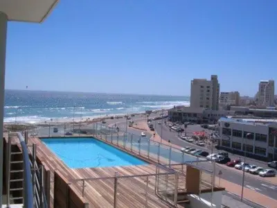 a view of a beach and a swimming pool at Private Blouberg Beachfront Getaway in Cape Town