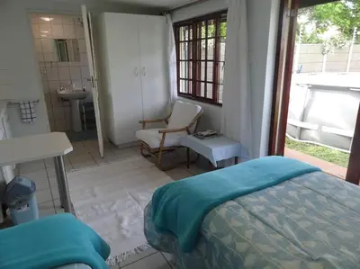 a bedroom with a bed and a bathroom with a sink at Cape Explore in Cape Town