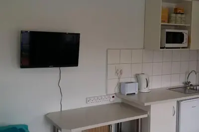 a kitchen with a tv hanging on the wall at Cape Explore in Cape Town