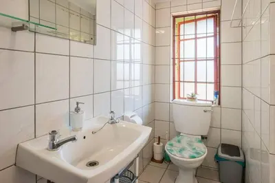 a bathroom with a sink and a toilet and a window at Cape Explore in Cape Town