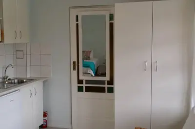 a kitchen with white cabinets and a mirror at Cape Explore in Cape Town