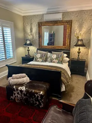 a bedroom with a large bed and a mirror at French Manor 2 Stellenbosch in Stellenbosch