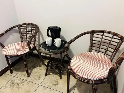 two chairs and a table with cups on it at Parow city -Star Legend Lodge in Cape Town