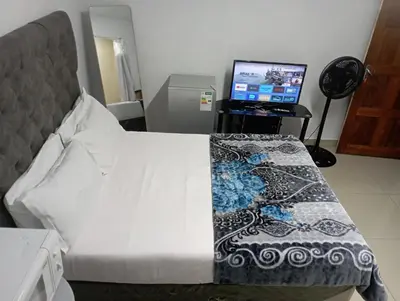 a bed in a room with a computer monitor at The trout Lodge in Cape Town