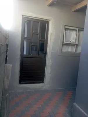 a room with a door and a window at The trout Lodge in Cape Town