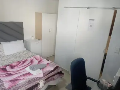 a bedroom with a bed with a laptop on it at The trout Lodge in Cape Town