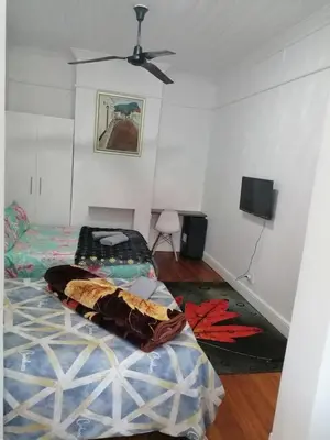 a bedroom with a bed and a ceiling fan at 37 Grant prix lodge in Cape Town
