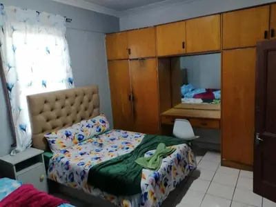 a bedroom with a bed and a dresser and a desk at 37 The trout Lodge in Cape Town