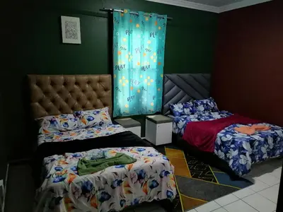 a bedroom with two beds and a blue curtain at 37 The trout Lodge in Cape Town