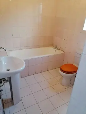 a bathroom with a toilet and a tub and a sink at 37 The trout Lodge in Cape Town