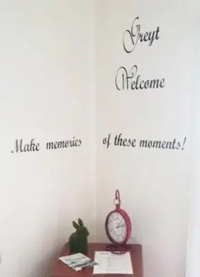 a clock on a table in a room with three words at Greyt House selfcatering house in Greyton SA in Greyton