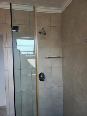 a shower with a glass door in a bathroom at Spacious Double Room with Pool, Free WiFi, Self-Catering Kitchen in Cape Town