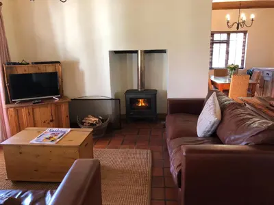 a living room with a couch and a wood stove at Bo La Motte Farm Cottages in Franschhoek