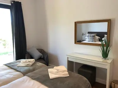 a bedroom with a mirror and a bed and a chair at Bo La Motte Farm Cottages in Franschhoek