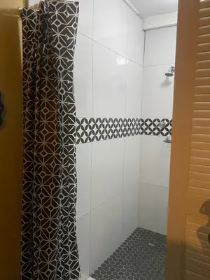 a shower with a black and white shower curtain at Flaming Place in Cape Town