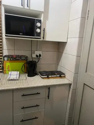 a small kitchen with a microwave and a stove at Flaming Place in Cape Town