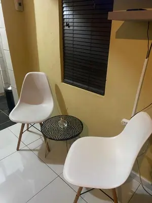 two white chairs and a table in a room at Flaming Place in Cape Town