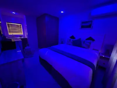a blue bedroom with a bed in a room at Serena Inn room 2 in Cape Town