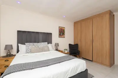 a bedroom with a large bed and a wooden cabinet at Serena Inn room 4 in Cape Town