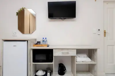 a living room with a tv on a wall at Serena Inn room 4 in Cape Town