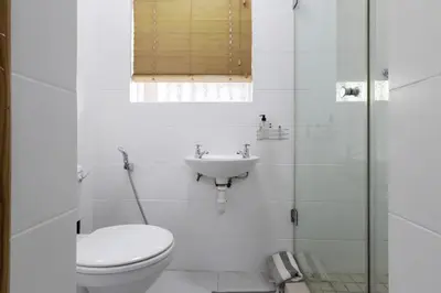 a white bathroom with a toilet and a sink at Serena Inn room 4 in Cape Town