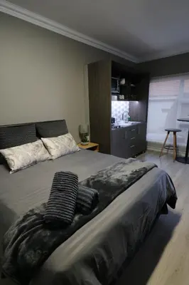 a bedroom with a bed with two towels on it at Charming Modern Bedsitter in Cape Town