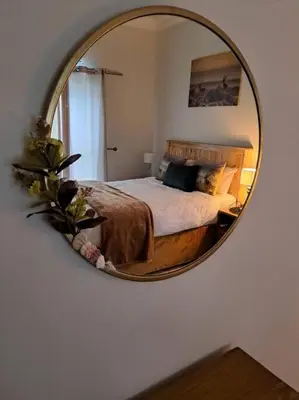 a bedroom with a bed with a mirror on the wall at Serena Inn Apartment no5 Self Catering in Cape Town