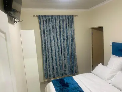 a bedroom with a bed and a blue curtain at Sabbath Lodge VIP in Cape Town