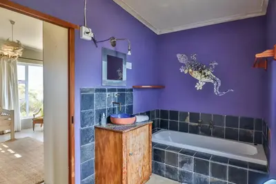 a purple bathroom with a tub and a sink at Mountain View in Bettyʼs Bay